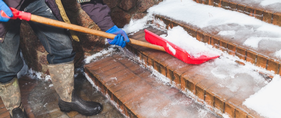 Storm crew clearing snow from a homeowner’s steps in North Mankato, MN.