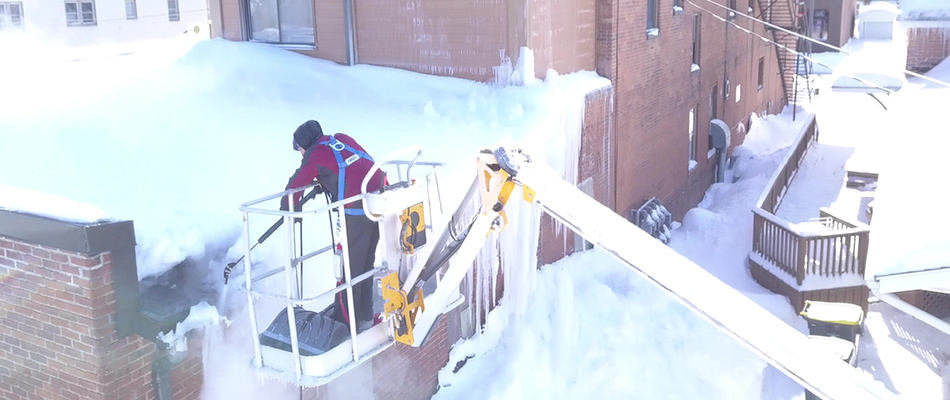 Storm technician assessing ice dam buildup on a roof in Mankato, MN.